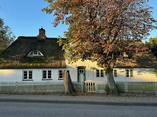 Altes Friesenhaus mit Sanierungsbedarf und Wohnungen im ehemaligen Wirtschaftsgebäude