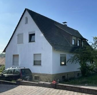 Modernisierungsbedürftiges Einfamilienhaus mit Garage und Garten.