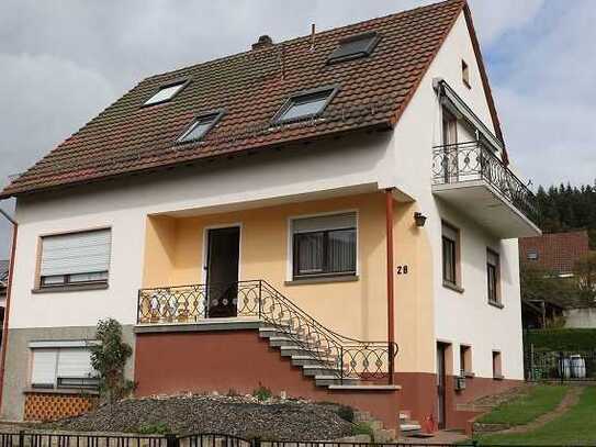 Freistehendes Einfamilienhaus mit großzügigen Rasengrundstück und einem Carport.