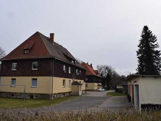 zwei Mehrfamilienhäuser mit Mietergärten und Garagen