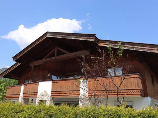 Ein großes Haus mit zwei Wohneinheiten in einer ruhigen Straße, umgeben von wunderschöner Natur