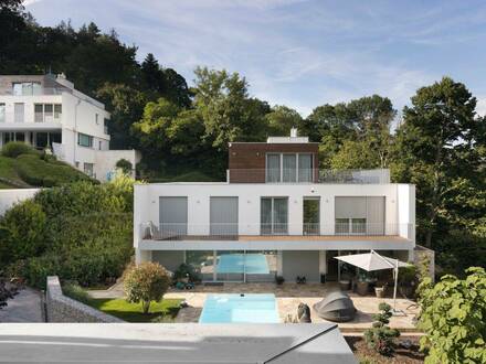 Exklusive Villa mit einem eigenen Hauslift, einem Pool und Blick auf die Grünfläche.