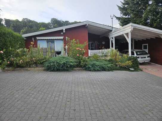 Haus in der Natur, umgeben von Bäumen und Wiesen