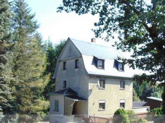 Einfamilienhaus mit großer Garage und Waldgrundstück.