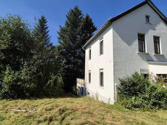 Altes Haus auf großem, grünen Grundstück