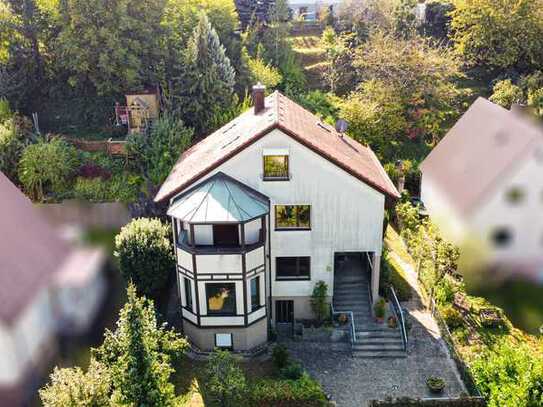 Freistehendes Einfamilienhaus mit traumhafter Weitsicht, großzügigem Hanggarten und zwei Garagen