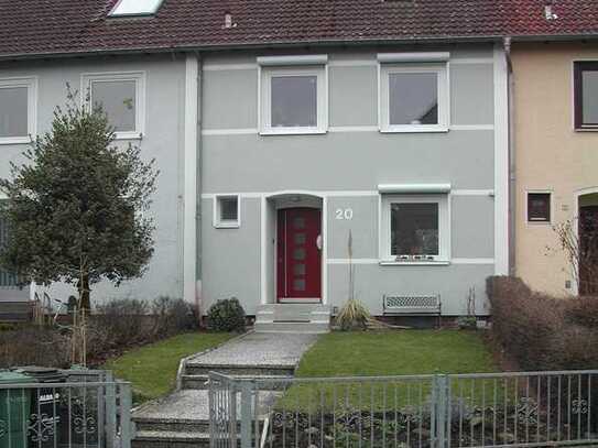 Reihenmittelhaus mit großen Fenstern und kleinem Garten
