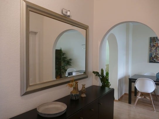 Modernly furnished apartment in a renovated old building and garden view.