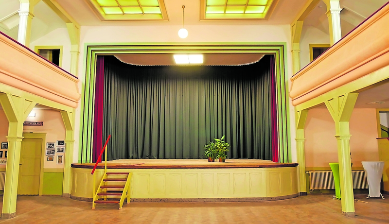 Der Saal Löwer mit einer großzügigen Bühne und aufwendig gearbeiteten Holzemporen steht unter Denkmalschutz. Die Tür links von der Bühne führt zur Puschkin-Bar, die Tür rechts zur Künstlergarderobe. Foto: srä