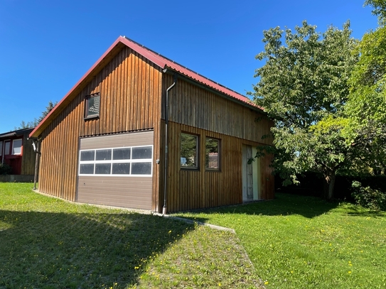 Einfamilienhaus mit Photovoltaikanlage und modernen Nebengebäuden