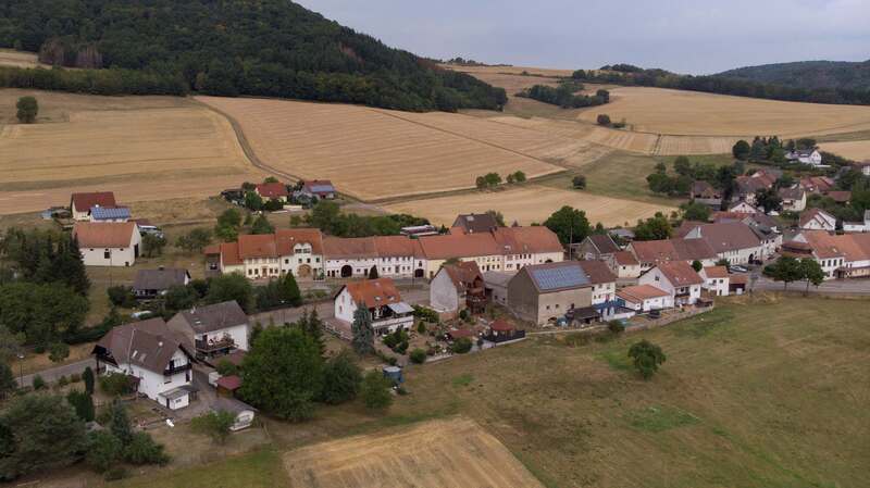 Eine Reihe von früheren Bauernhäusern im typischen Stil der Westpfalz steht in Rathsweiler unter Denkmalschutz (Bildmitte). Links dahinter liegt etwas erhöht  das Neubaugebiet.  Foto: Sayer