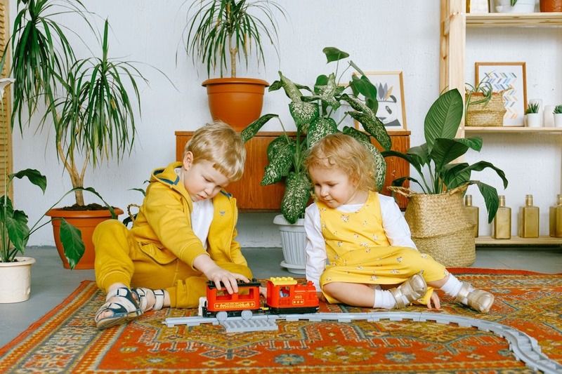 Entzückender Kleiner Junge Und Mädchen, Die Mit Spielzeugeisenbahn Spielen