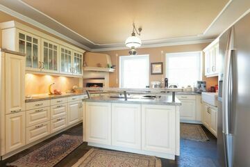 Die moderne, weiße Küche im Landhausstil mit drei Kochfeldern - Wok -