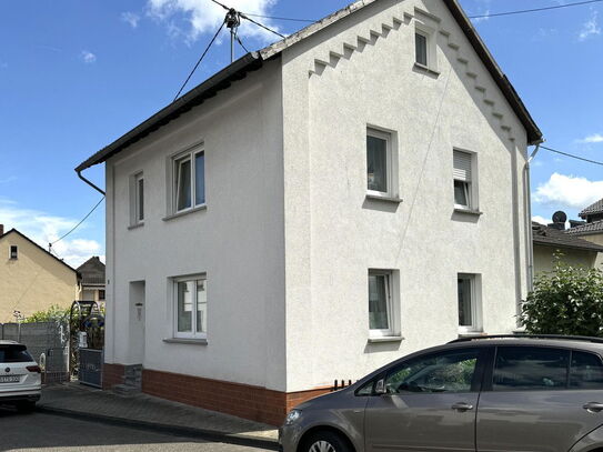 Einfamilienhaus mit Pool, Garten und Carport.