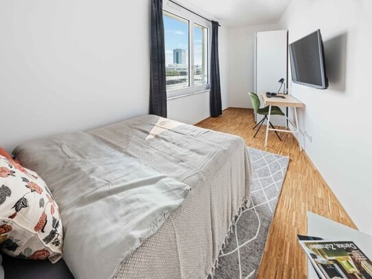 Helles Zimmer mit Fernseher in einem Coliving-Apartment in München