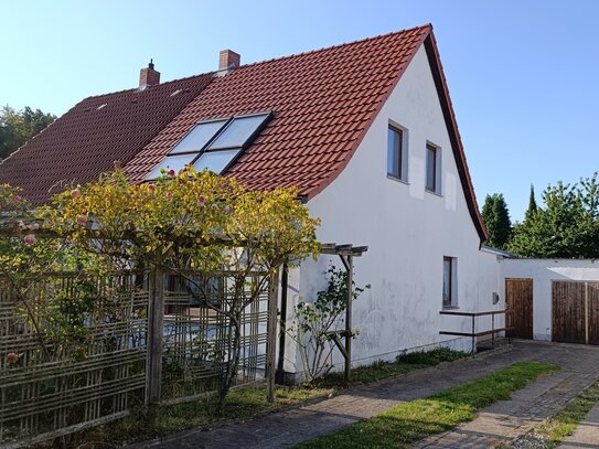 Doppelhaushälfte eines Siedlungshauses mit großem Garten und Garage