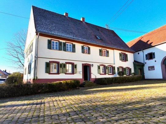 Historischer Dreiseithof mit angrenzenden landwirtschaftlichen Flächen