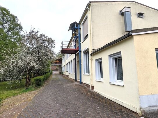 Gewerbegrundstück bebaut mit Büro- bzw. Wohngebäude und Hallen- bzw. Werkstattgebäude in grüner Umgebung