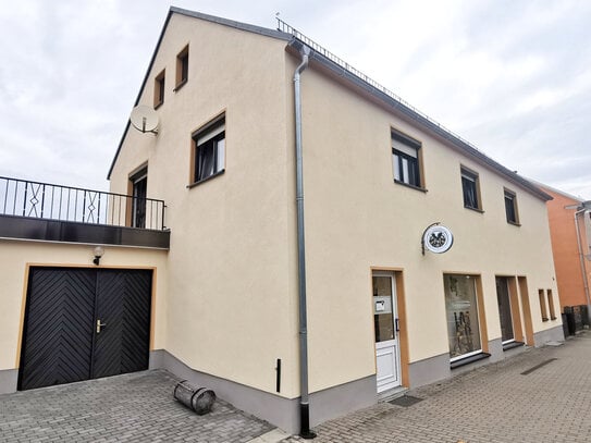 Einfamilienhaus mit Wohnung, Balkon, Garage und vermieteter Gewerbeeinheit als Einliegerwohnung